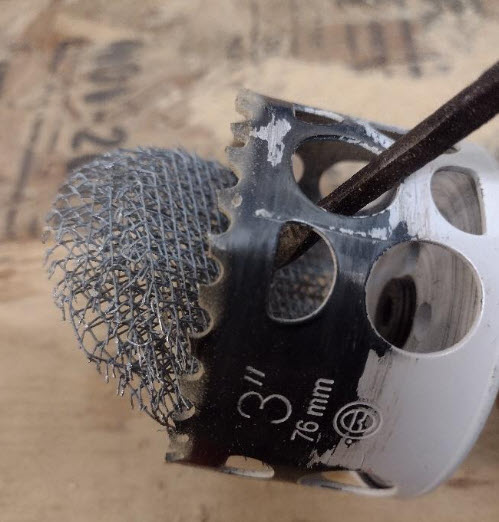 Screen circles being removed from the hole saw. 